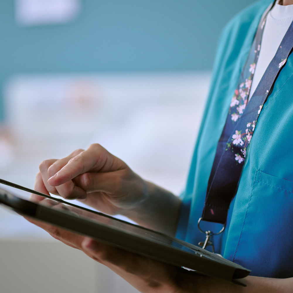 Caucasian,Middle,Aged,Woman,Wearing,Medical,Scrubs,Using,Digital,Tablet